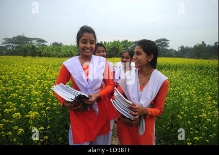 Village du Bangladesh les filles vont à l'école dans le champ avec les manuels scolaires à l'extérieur rassemblement de Dhaka. Banque D'Images