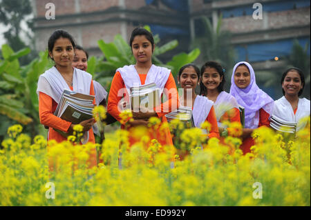 Village du Bangladesh les filles vont à l'école dans le champ avec les manuels scolaires à l'extérieur rassemblement de Dhaka. Banque D'Images