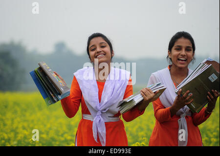 Village du Bangladesh les filles vont à l'école dans le champ avec les manuels scolaires à l'extérieur rassemblement de Dhaka. Banque D'Images