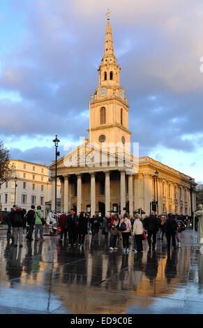 Les gens à l'extérieur de St Martin des Champs dans l'église sur Trafalgar Square après la pluie, London,UK - crépuscule d'hiver ; Banque D'Images