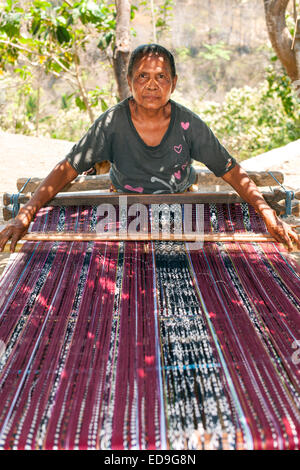 Sarongs traditionnels tissage femme indonésienne sur le bord de la route sur l'île de Flores en Indonésie. Banque D'Images