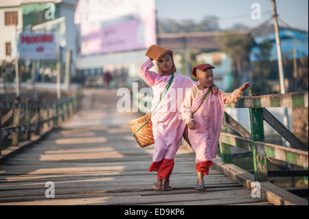 Deux jeunes moniales à pied par une passerelle au-dessus de la rivière Nam Pilu tôt le matin Banque D'Images