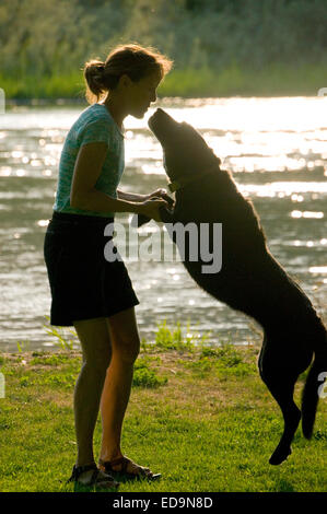 Femme adulte interagit avec son chien le long d'une rivière dans le centre de l'Oregon Banque D'Images