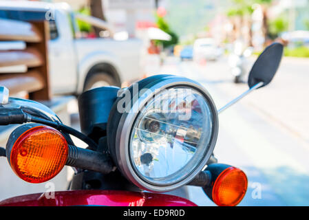 Moto rouge projecteur shot close-up sur la rue Banque D'Images