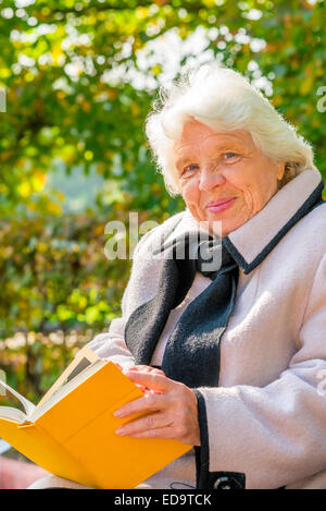 Portrait d'une grand-mère heureuse sur un banc de parc Banque D'Images