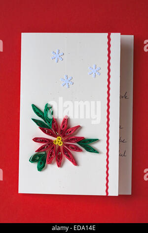 Canetage papier artisanal sur carte de Noël isolé sur fond rouge Banque D'Images