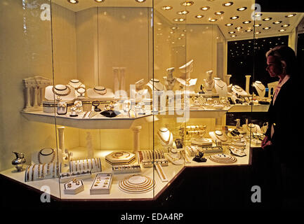 Une femme à Istanbul, Turquie tourisme, visites l'impressionnante démonstration de bijoux en or dans la vitrine d'un magasin qui est illuminé la nuit. Banque D'Images