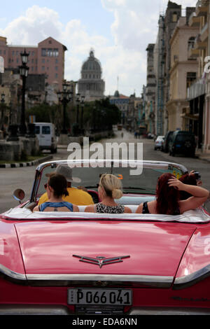 Les touristes voyageant dans une voiture décapotable vintage classique à La Havane, Cuba avec le Capitolio Nacional en arrière-plan Banque D'Images