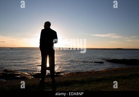 Le président américain Barack Obama entre dans le coucher du soleil sur l'eau au point de Brenton, 29 août 2014 à Newport, Rhode Island. Banque D'Images