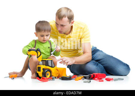 Kid et son père la réparation du tracteur jouet Banque D'Images