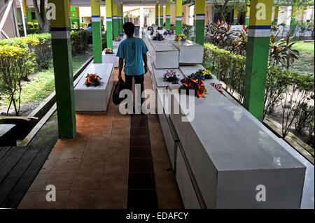 Pangkalan Bun. 4 janvier, 2015. Un homme passe devant les cercueils des victimes de vol AirAsia QZ8501 dans un hôpital de Pangkalan Bun, l'Indonésie. Le 4 janvier 2015. Un pilote indonésien qui participent à l'opération de recherche multinationale a dit ici le dimanche que trois autres corps ont été trouvés dans l'accident au large de Bornéo AirAsia côte. Ti'Kuncahya Crédit : B./Xinhua/Alamy Live News Banque D'Images