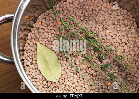 Les lentilles, le thym et le laurier en pot, prête pour la cuisson. Banque D'Images