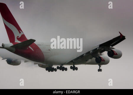 3 janvier 2015, l'aéroport de Heathrow, Londres. Les nuages bas et la pluie fournissent des conditions idéales pour observer service et 'vortex' débourrage comme humidité se condense sur les ailes d'avion à l'atterrissage. Avec la piste visible uniquement à la dernière minute, plusieurs avions ont dû effectuer une 'go-round', abandonnant leurs premières tentatives à la terre. Sur la photo : condesnses la vapeur d'eau sur les ailes d'un Airbus A380 de Qantas comme il se prépare à atterrir sur la piste d'Heathrow 27L. Banque D'Images