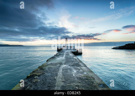 Le lever du soleil sur la jetée banjo sur la plage de Looe sur le sud de la côte de Cornwall Banque D'Images