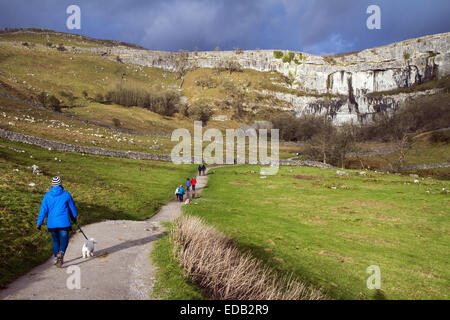 Les marcheurs sur le chemin de Malham Cove, une falaise de calcaire de 80m dans le Yorkshire Dales Banque D'Images