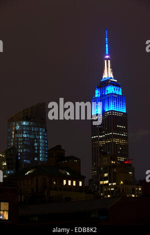 New York, USA. 08Th Jan, 2015. L'Empire State Building de New York est éclairé en bleu avec une sirène rouge rotatif pour saluer ce soir tombé Officiers de NYPD Rafael Ramos & Wenjian Liu. Credit : Oliver Dixon/Alamy Live News Banque D'Images