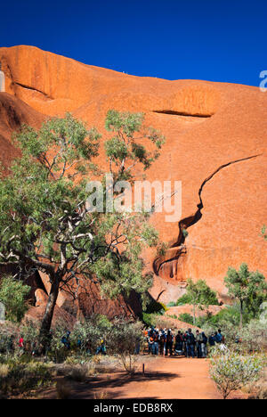 La consultation de groupe visite du site sacré à la base du monument Uluru (Ayers Rock), l'Australie Banque D'Images