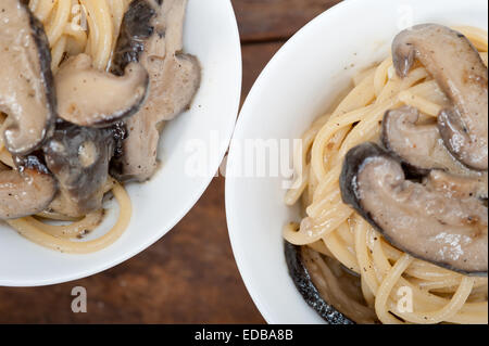 Les pâtes spaghetti italien et des champignons sauvages sur table en bois rustique Banque D'Images