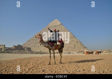 Les propriétaires de chameaux sur un chameau en face de la pyramide de Khéphren, Giza, Egypte Banque D'Images