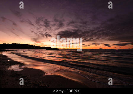 Les vagues de la mer formant une forme de coeur sur la plage au coucher du soleil Banque D'Images