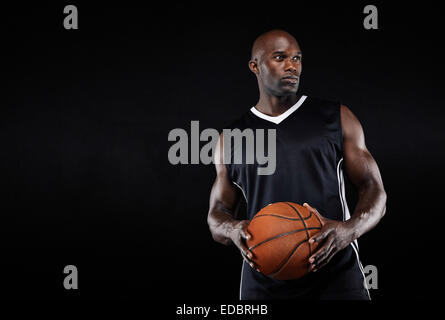 Droit de mettre en place les jeunes Afro-américain de basket-ball à l'athlète détenant une copie avec l'espace. Joueur de basket-ball musculaire. Banque D'Images