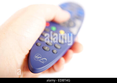 Un homme tenant une Ccable Virgin Media TV remote. Banque D'Images