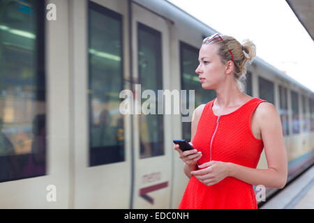 Jeune femme sur la plate-forme de la gare ferroviaire. Banque D'Images