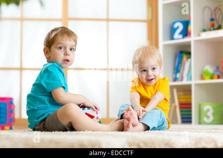 Deux petits garçons jouent ensemble avec les jouets éducatifs Banque D'Images