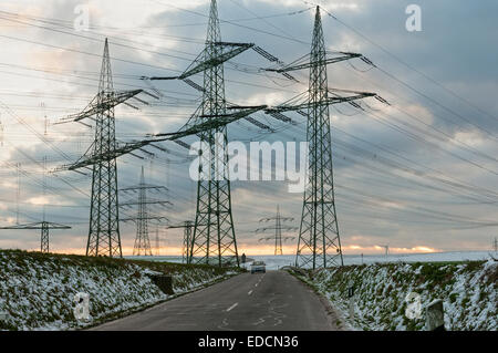 Pylônes électriques dans un stérile, paysage de neige, de l'Allemagne. Banque D'Images