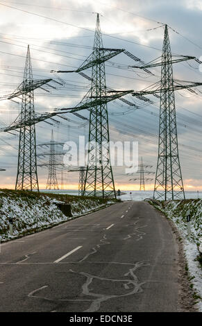 Pylônes électriques dans un stérile, paysage de neige, de l'Allemagne. Banque D'Images