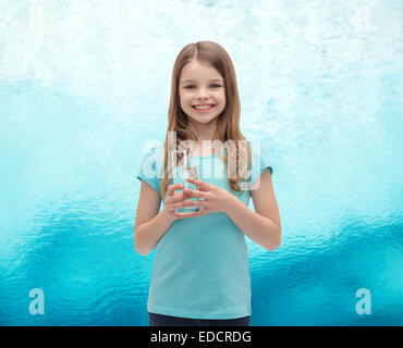 Smiling little girl avec verre de l'eau Banque D'Images