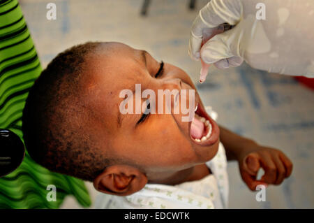 Un jeune garçon reçoit un vaccin oral contre la poliomyélite dans une clinique médicale à Pétionville golf club, le 13 juillet 2010 à Port-au-Prince, Haïti. Banque D'Images