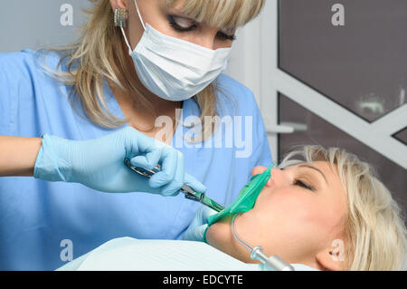 Dentiste avec patient, l'installation de barrage en caoutchouc Banque D'Images