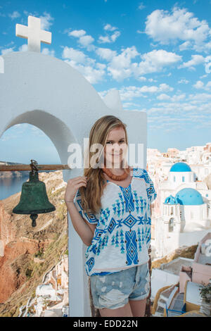 Fille debout sur les toits d'Oia, Santorini, Cyclades, îles grecques, Grèce Banque D'Images