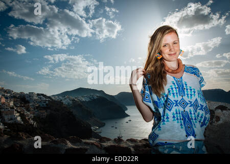 Fille blonde debout sur les toits d'Oia, Santorini, Cyclades, îles grecques, Grèce Banque D'Images