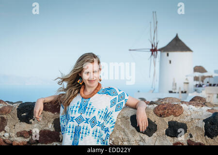 Fille debout sur les toits d'Oia, Santorini, Cyclades, îles grecques, Grèce Banque D'Images