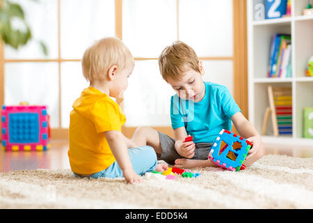 Deux petits garçons jouent ensemble avec les jouets éducatifs Banque D'Images