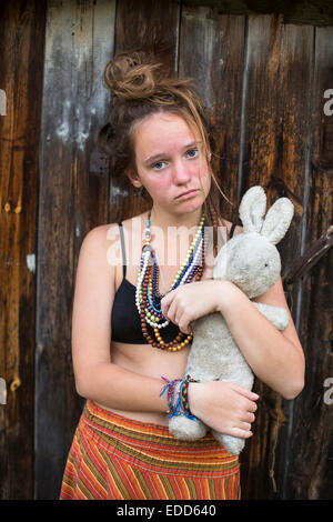 Triste jeune fille de l'adolescence avec de vieux lapin jouet entre les mains de l'extérieur, dans les zones rurales. Banque D'Images