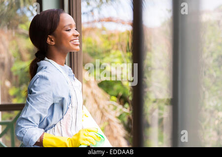 Cheerful young African ménagère en regardant par la fenêtre Banque D'Images