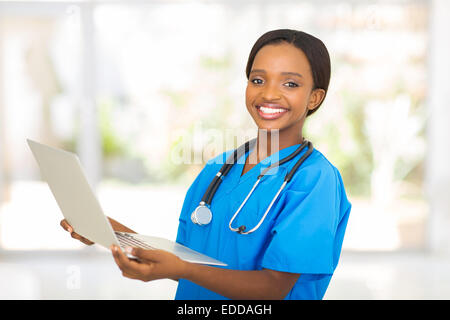 Happy African Medical worker holding laptop computer at hospital Banque D'Images