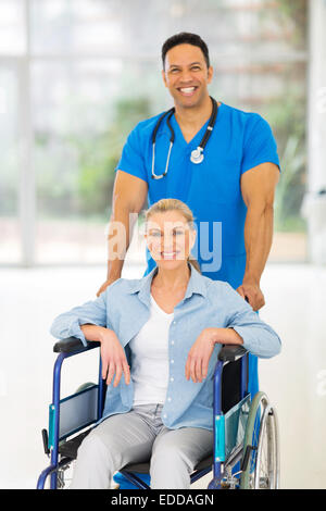 Handsome medical infirmier en prenant soin de senior patient in wheelchair Banque D'Images