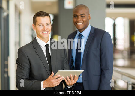 Deux beaux hommes d'using tablet pc in modern office Banque D'Images