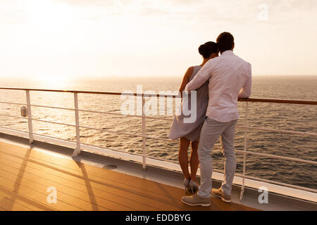 Vue arrière du jeune couple hugging at sunset on cruise ship Banque D'Images