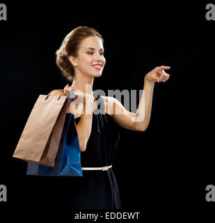 Smiling woman in dress with shopping bags Banque D'Images