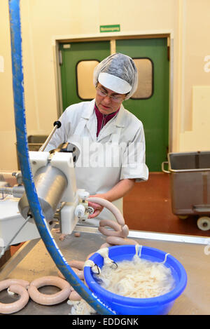 Femme travaillant à la production de saucisses dans une boucherie Banque D'Images