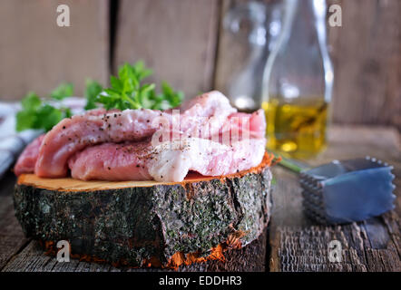 La viande crue sur la planche de bois et sur une table Banque D'Images