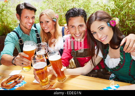 Les amis de la bière en Bavière clinking glasses en été dans un jardin de bière Banque D'Images