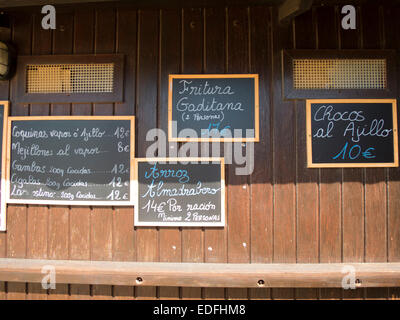 Quatre plaques noires à la main, en espagnol brun bois mur avec des plats typiques de l'alimentation menu restaurant en Espagne Banque D'Images