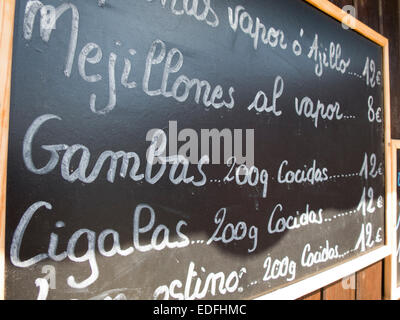 Des plaques noires à la main, en espagnol brun bois mur avec des plats typiques de l'alimentation menu restaurant en Espagne Banque D'Images