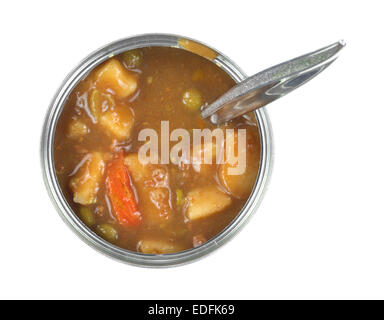 Vue de dessus d'une boite de conserve de Ragoût aux légumes qui s'ouvre avec une cuillère insérée sur un fond blanc. Banque D'Images